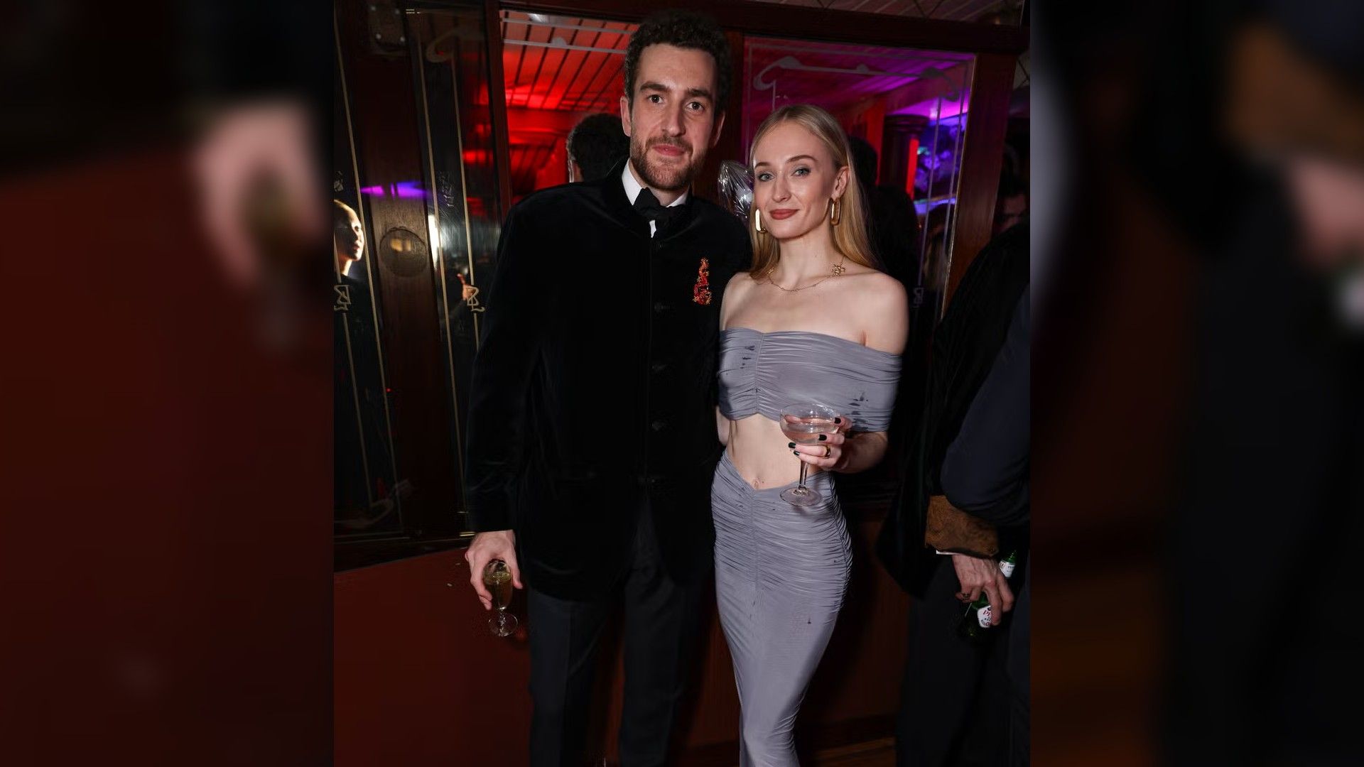 Actrița Sophie Turner într-o rochie de seară albastru pal și Peregrine Pearson într-un costum negru pozează împreună