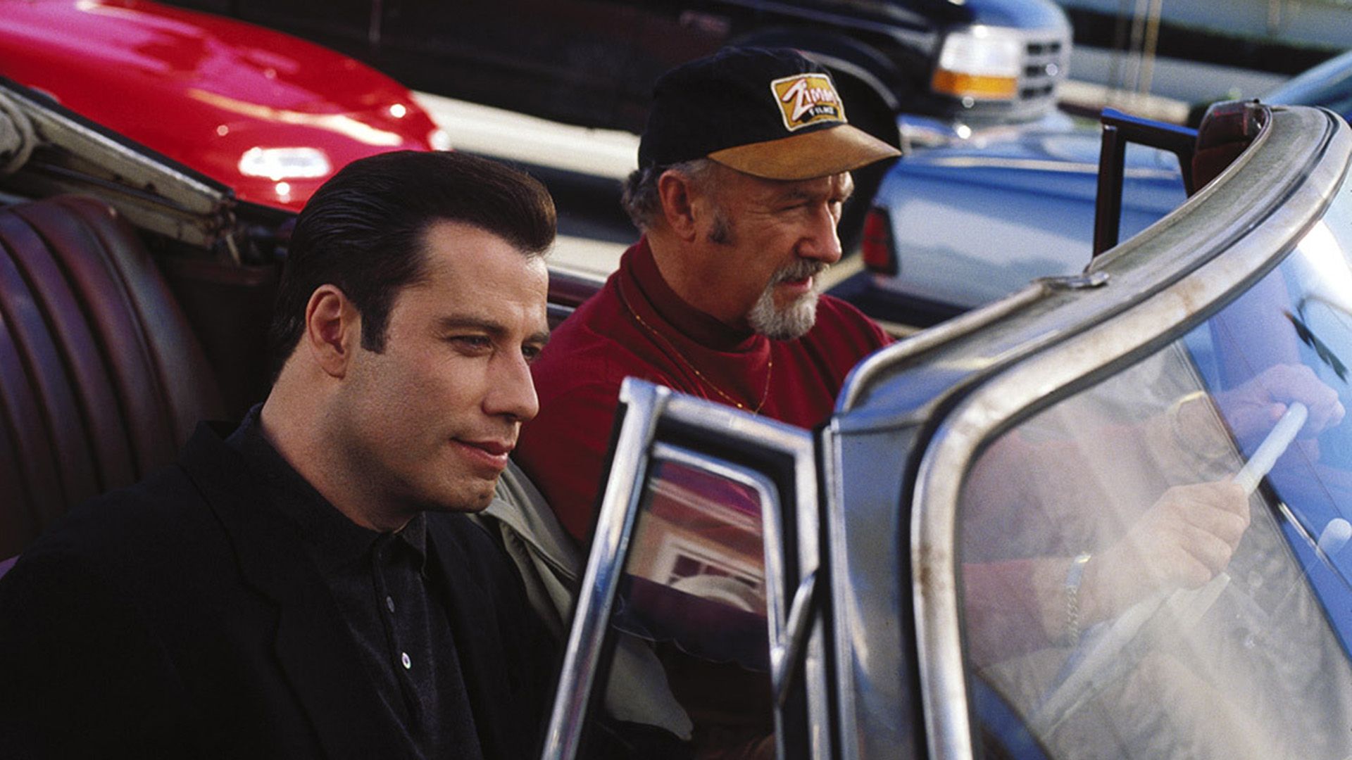 John Travolta și Gene Hackman într-un decapotabil roșu într-o scenă din filmul 'Get Shorty'