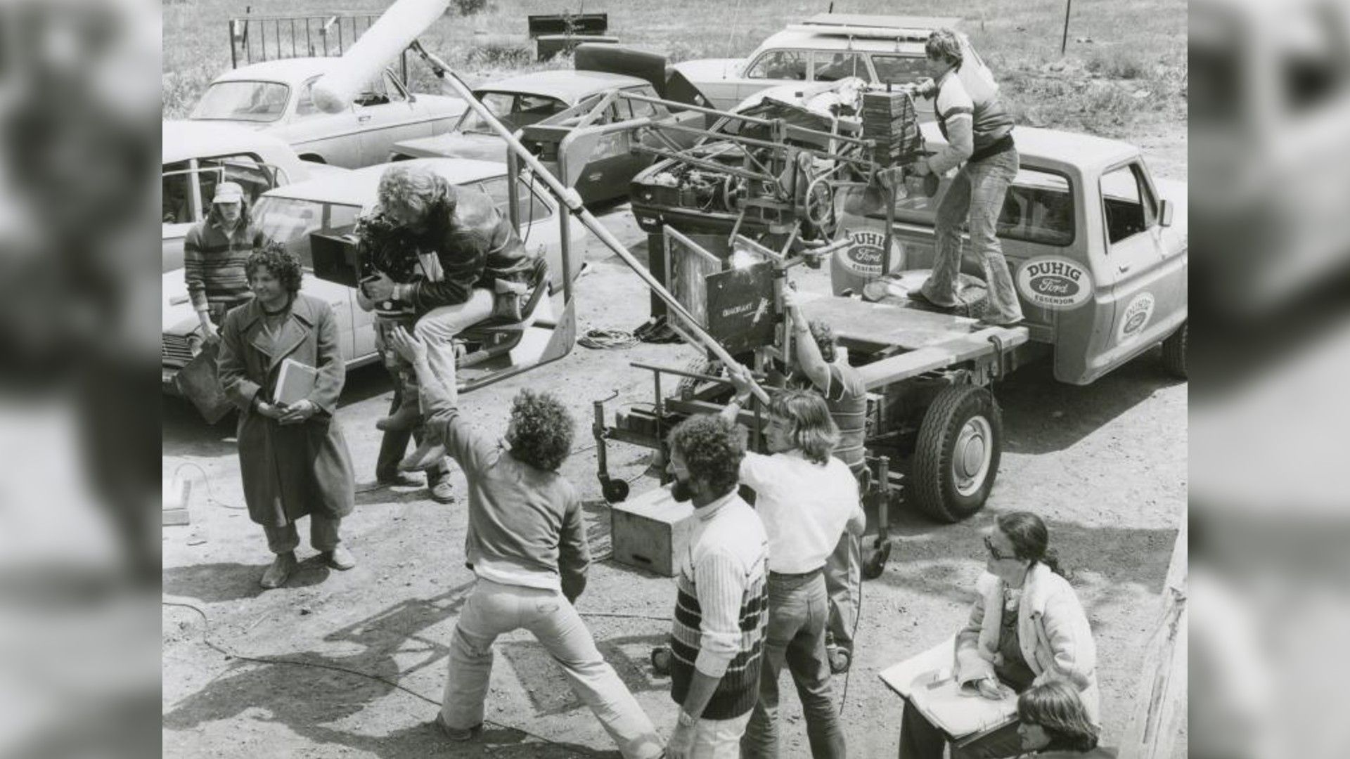 Fotografie a echipei "Mad Max" pe platoul de filmare. Regizorul George Miller poate fi văzut în stânga, îmbrăcat într-o haină