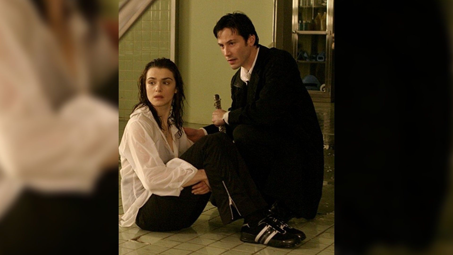 Rachel Weisz și Keanu Reeves stând pe podea unul lângă celălalt