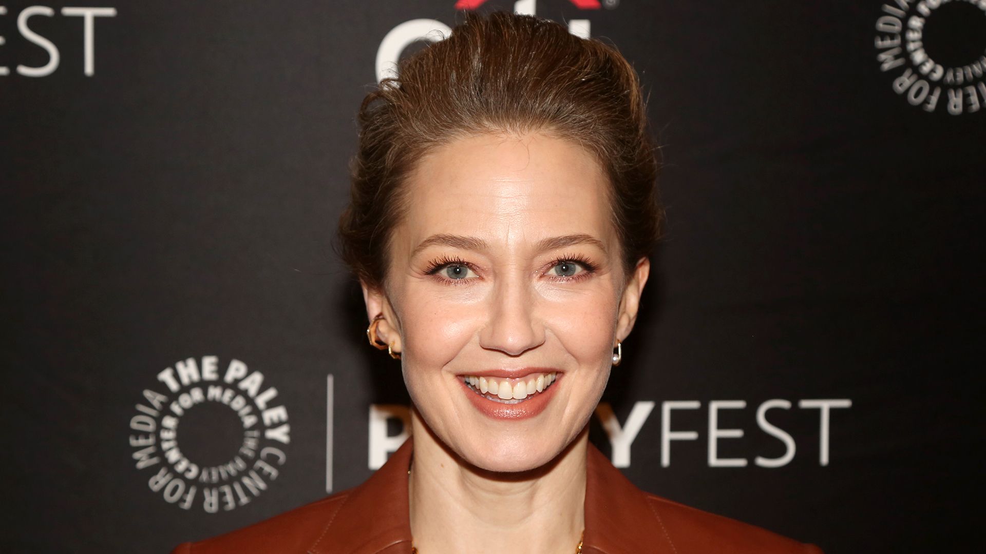 Actrița Carrie Coon cu un zâmbet larg în prim-plan