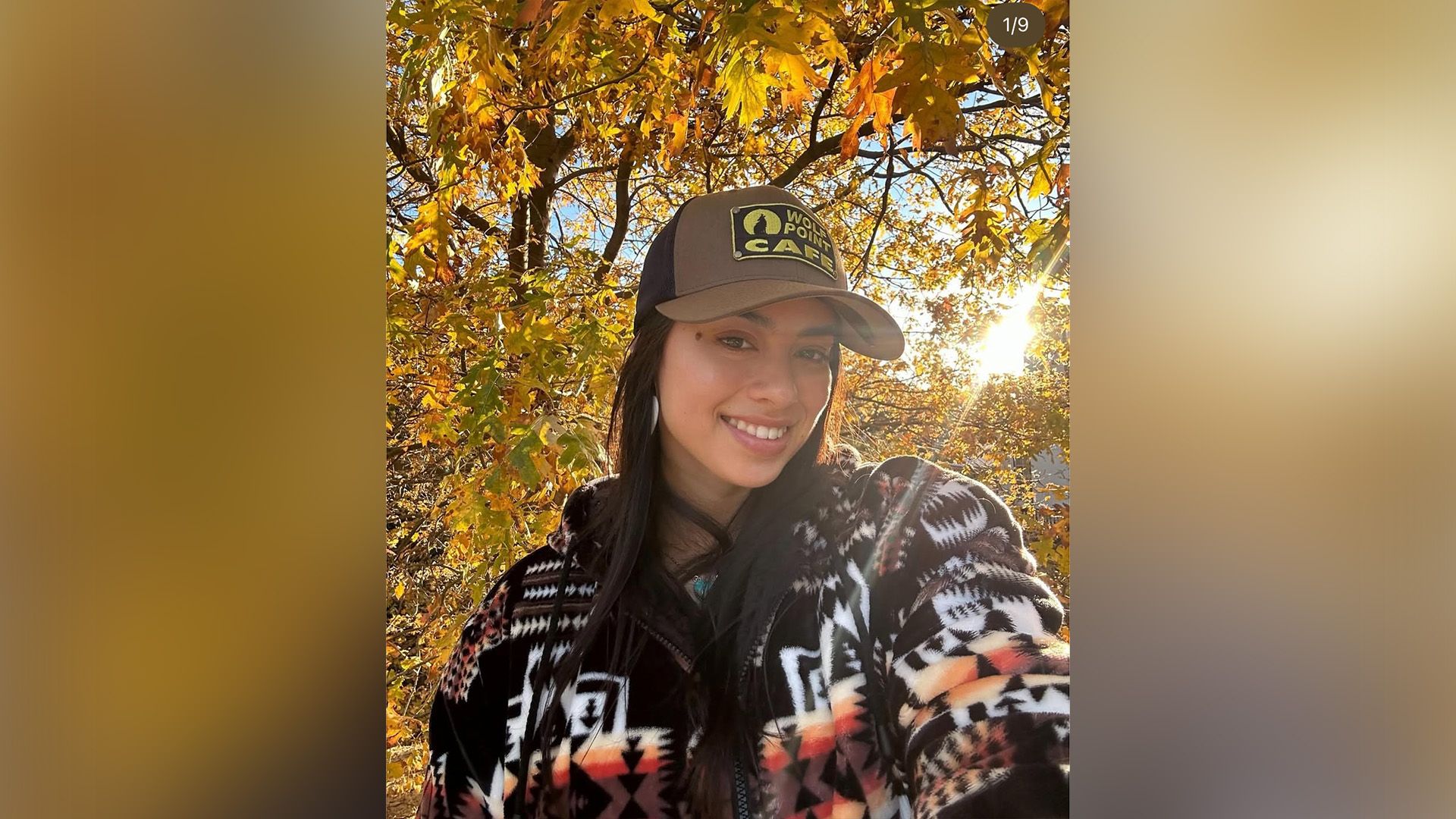 Actrița Amber Midthunder într-o șapcă de baseball și pulover călduros pe fundalul frunzișului de toamnă