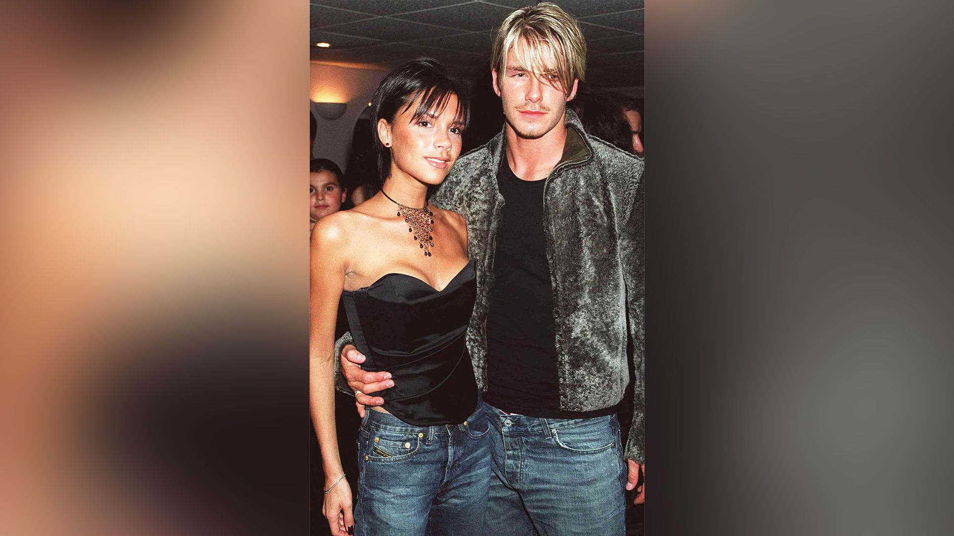 David Beckham tânăr o îmbrățișează pe Victoria Adams de talie la un eveniment social