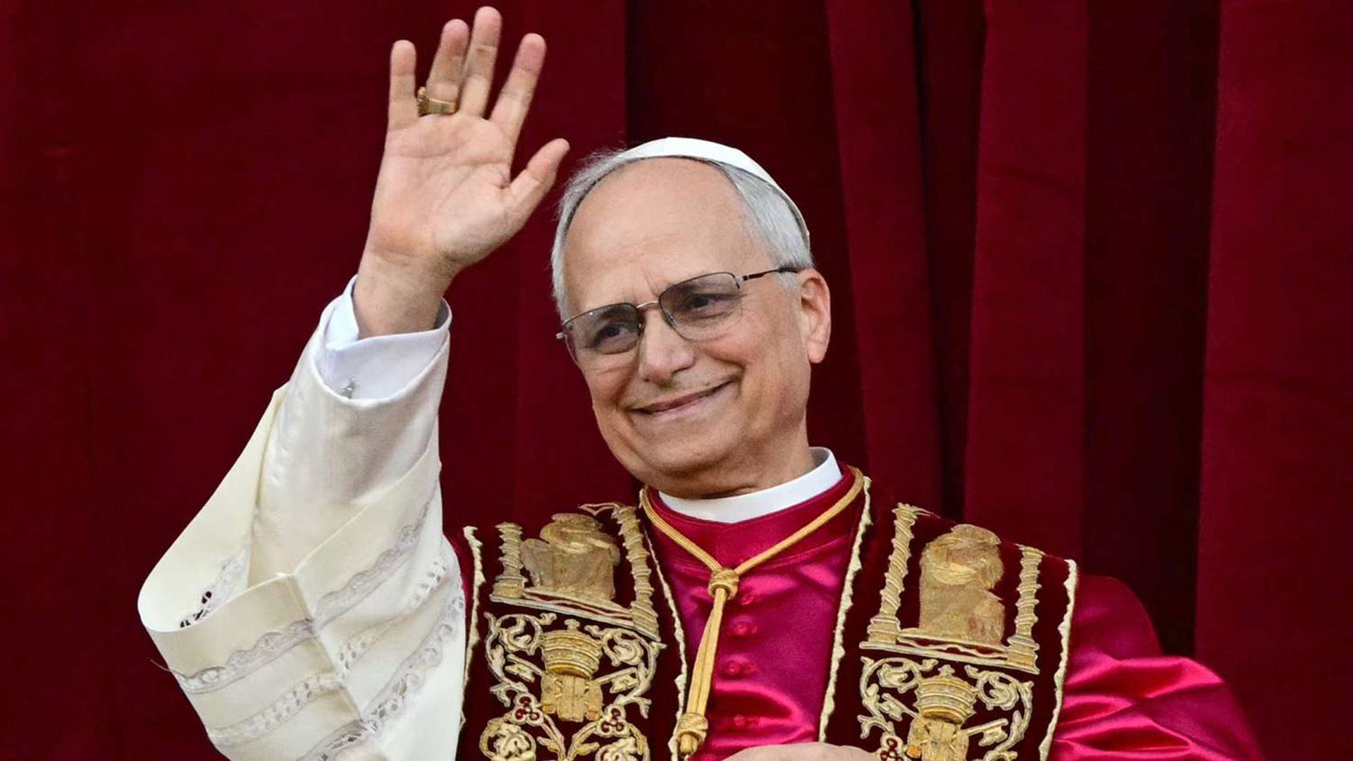 Papa Leon al XIV-lea (Robert Francis Prevost), îmbrăcat în roșu, își flutură mâna în semn de salut