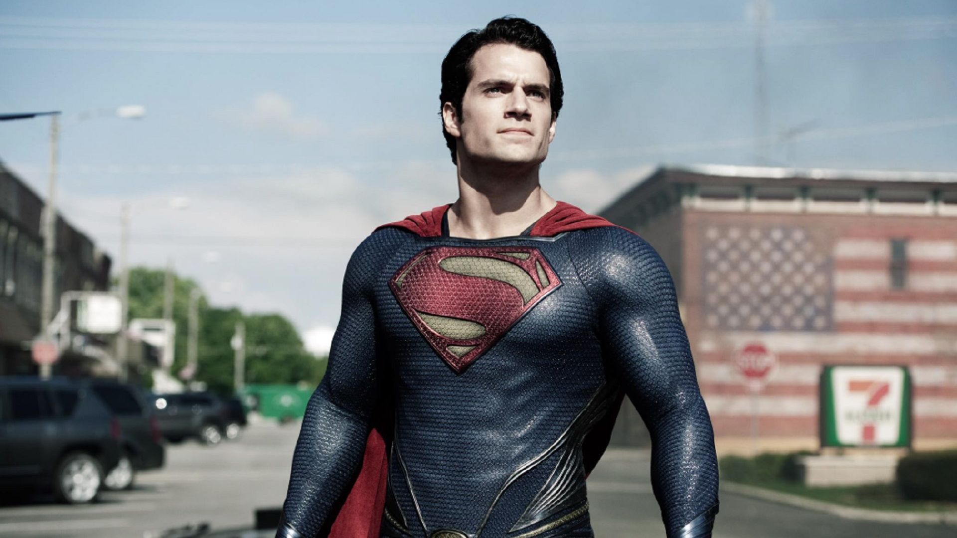 Henry Cavill în costumul Superman se uită în sus în timp ce stă pe stradă
