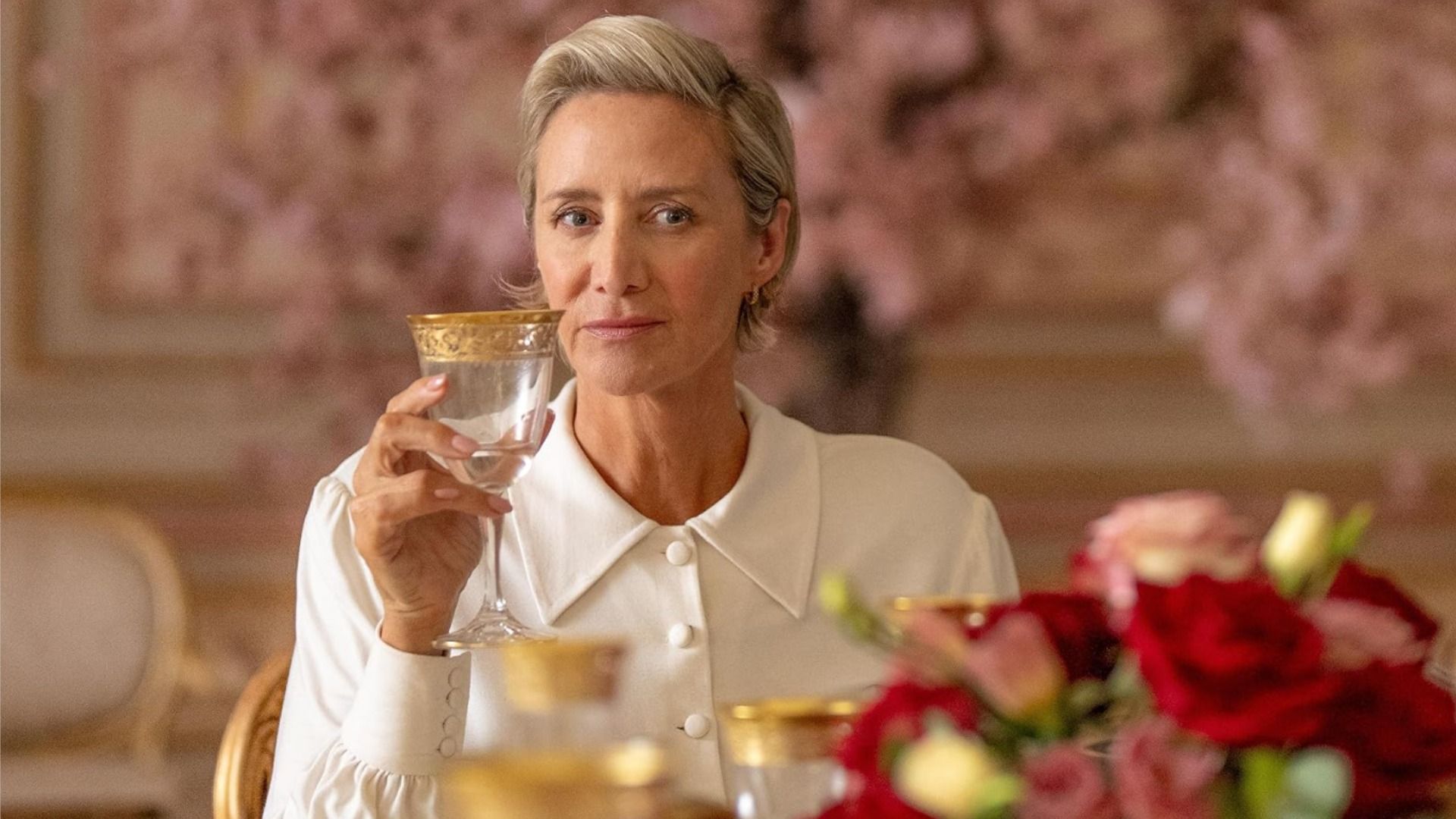 Actrița Janet McTeer stând într-o bluză albă cu un pahar în mână