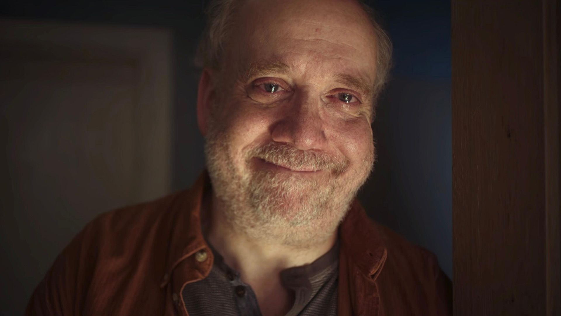 Paul Giamatti zâmbește cu ochii plini de lacrimi