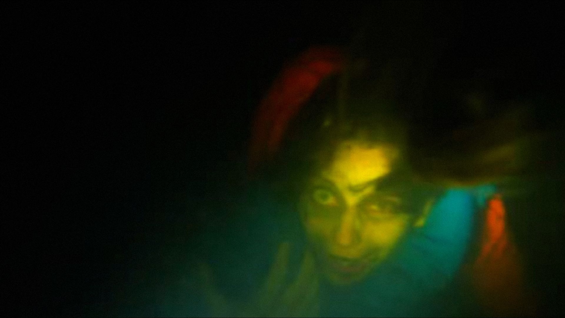 Femeie în haine portocalii se uită la cameră sub apă