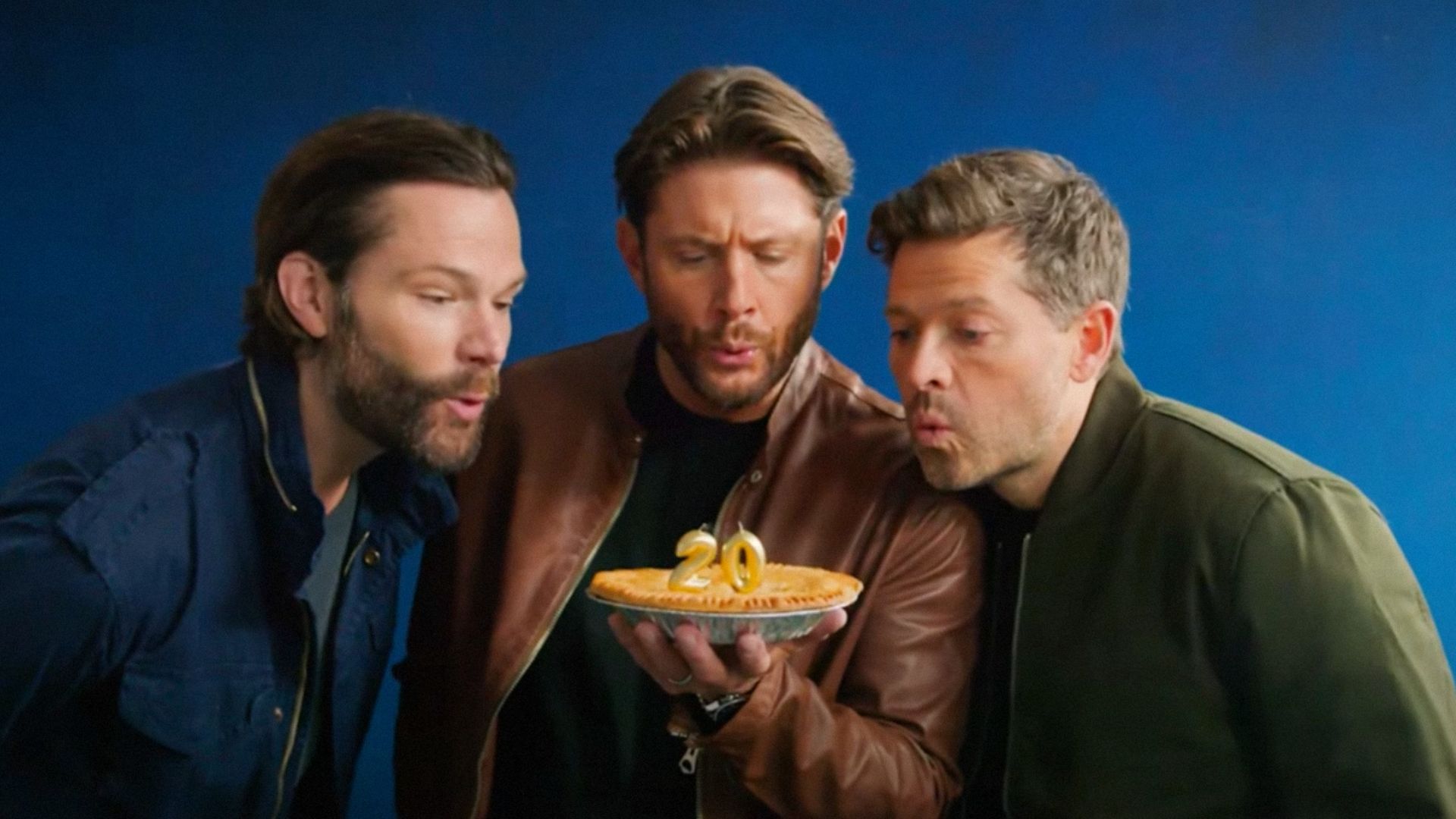 Actorii Jared Padalecki, Jensen Ackles și Misha Collins suflă în lumânările de pe un tort