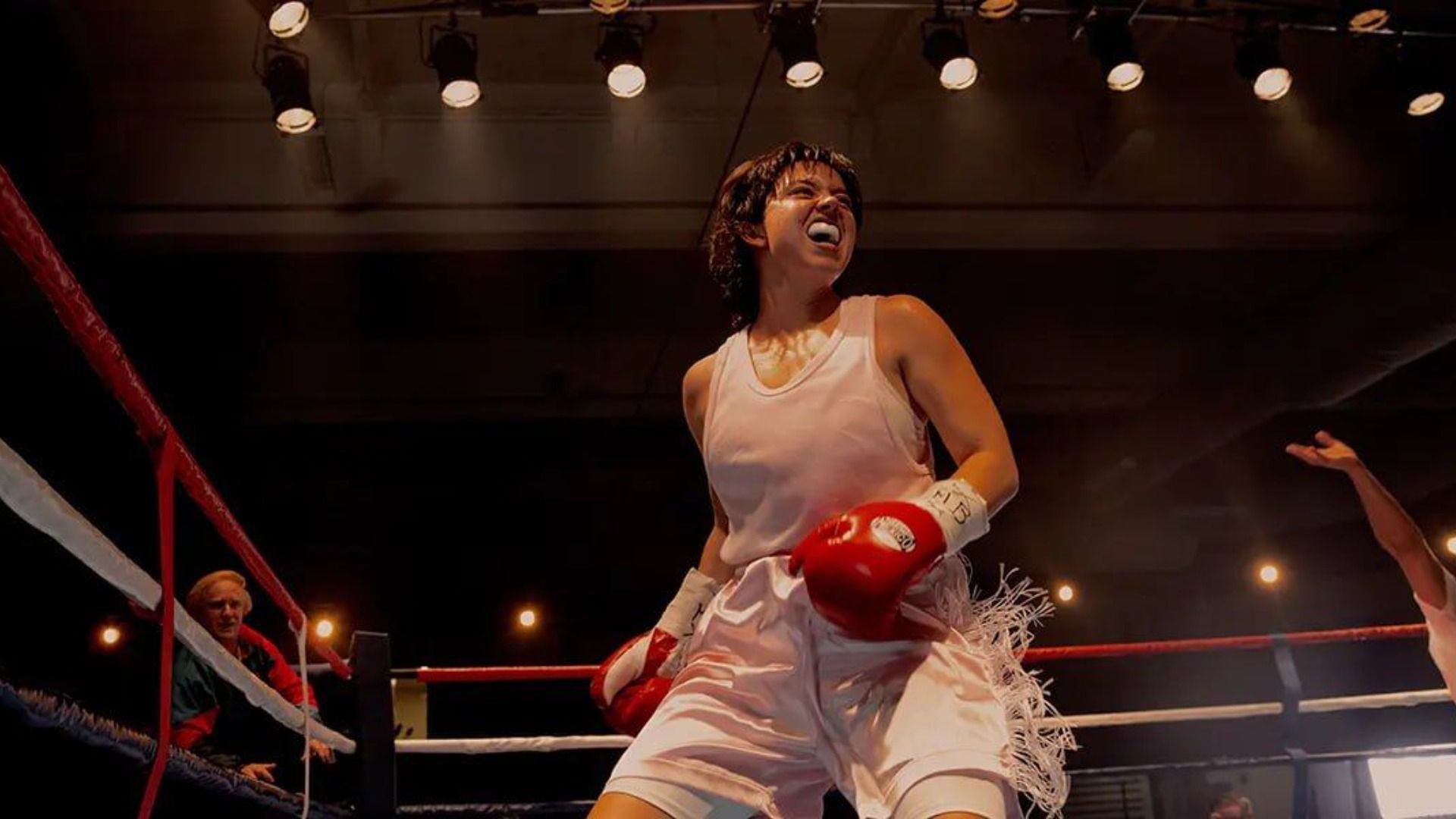Actrița Sydney Sweeney într-un tricou alb și cu mănuși roșii stă într-un ring de box