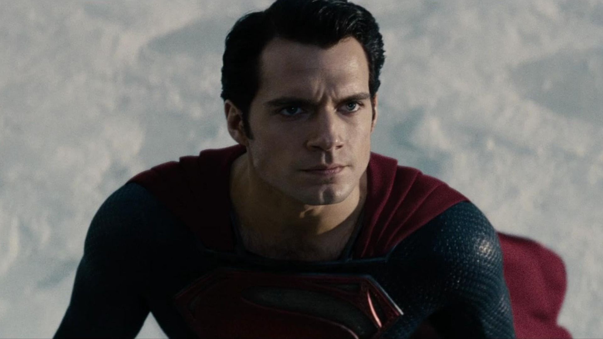 Actorul Henry Cavill într-un costum de supererou albastru și roșu cu litera S pe piept