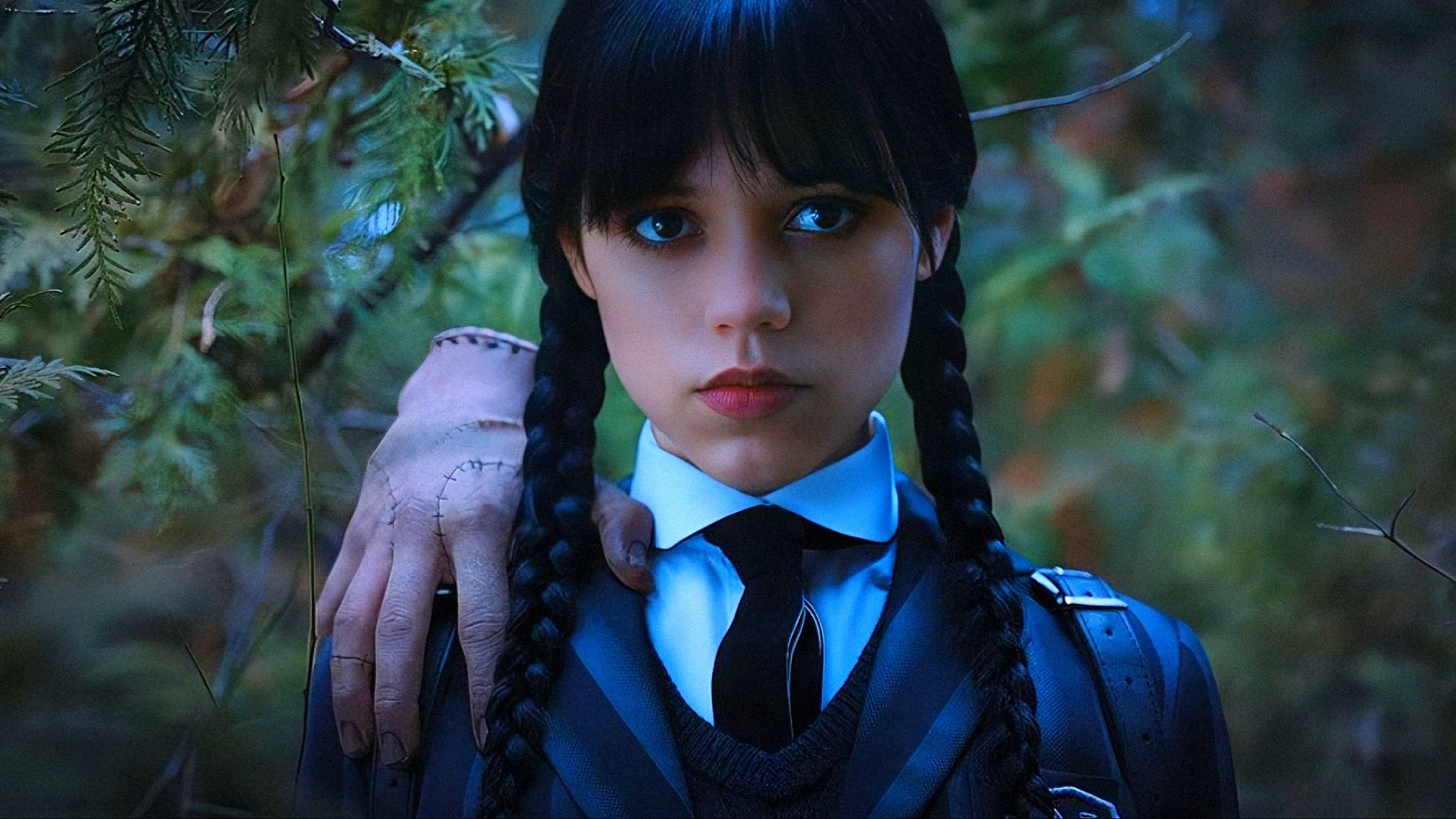 Actrița Jenna Ortega în uniformă școlară cu o mână pe umăr se uită la cameră