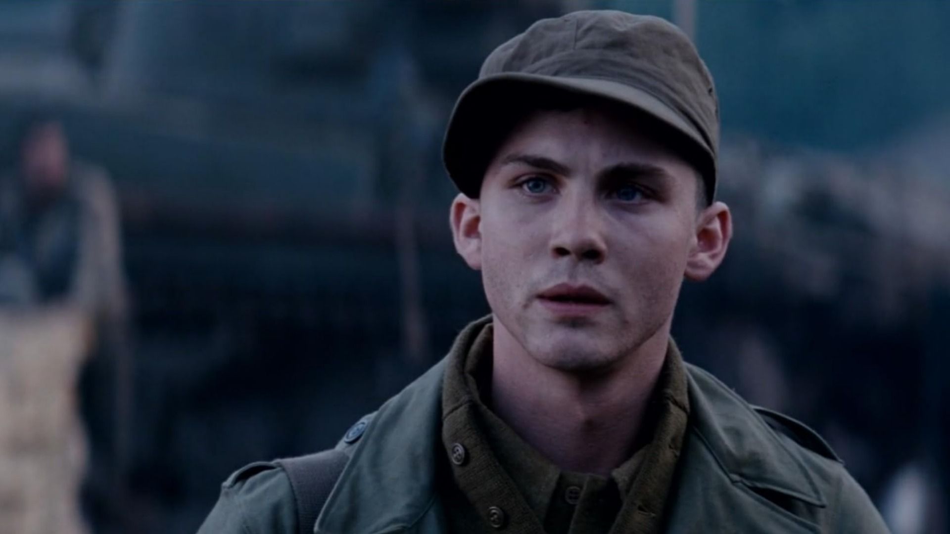 Actorul Logan Lerman în uniformă militară cu o șapcă pe cap