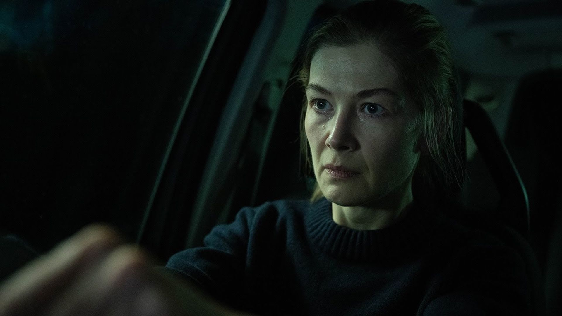 Telefon pe suport, actrița Rosamund Pike stă la volanul unei mașini