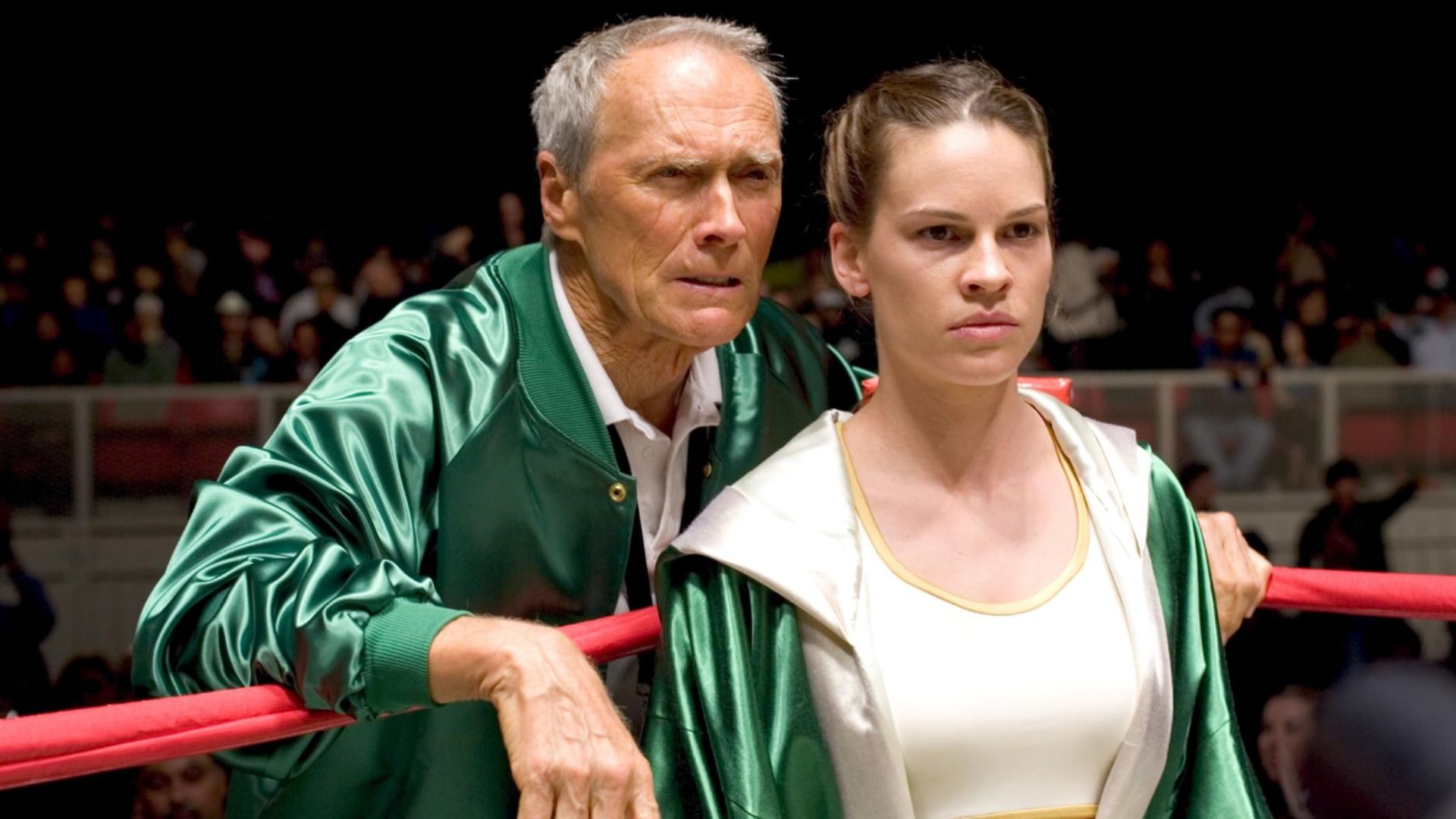 Actorii Clint Eastwood și Hilary Swank stau în haine verzi pe un ring de box