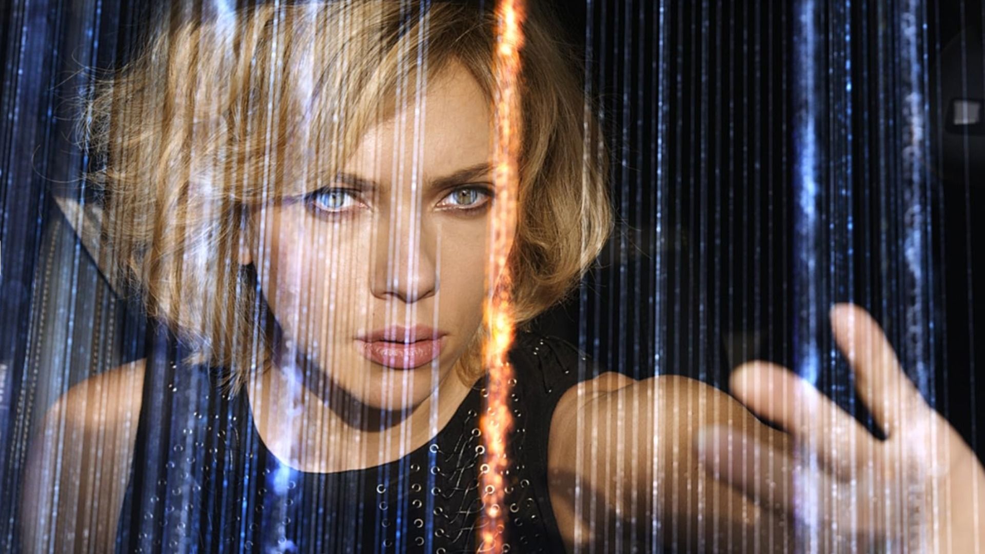 Actrița Scarlett Johansson într-o rochie neagră cu mâna ridicată printre linii sclipitoare