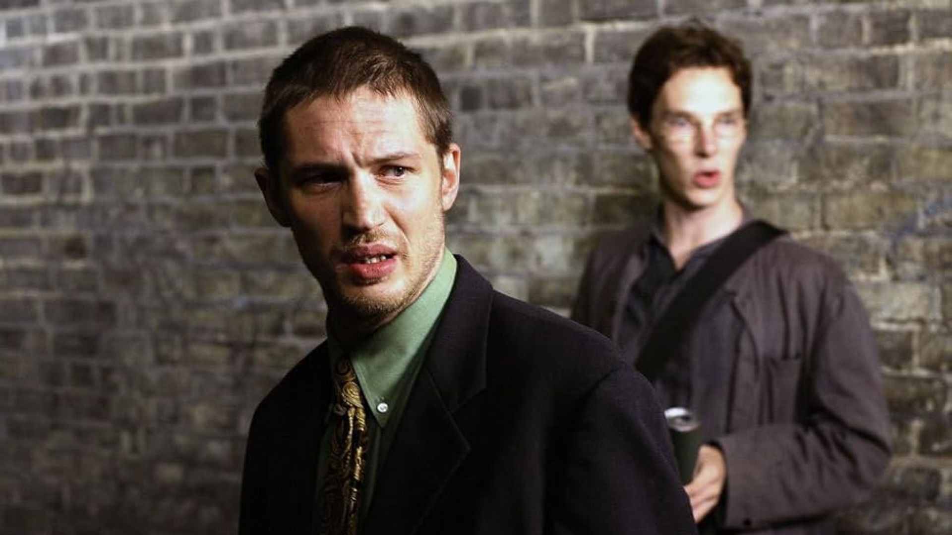 Tom Hardy și Benedict Cumberbatch tineri stând lângă un zid de cărămidă