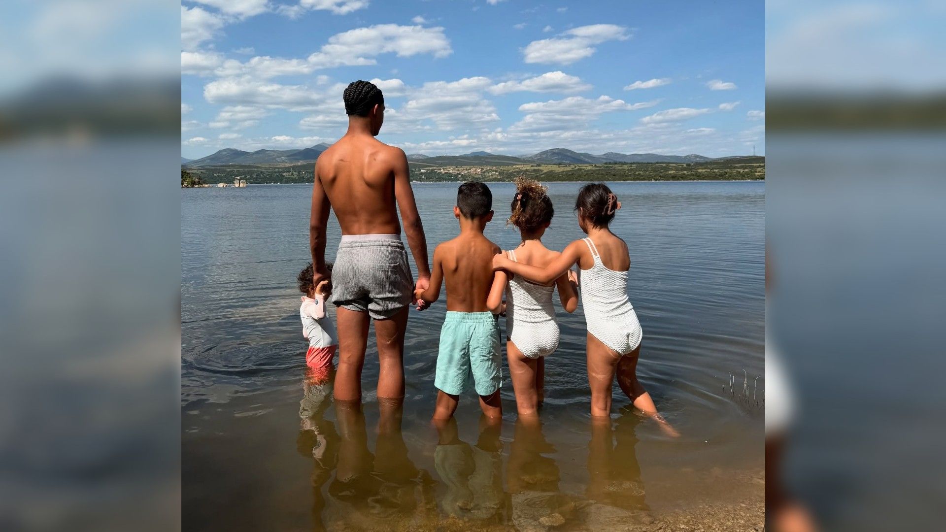 Cei cinci copii ai lui Cristiano Ronaldo stau cu spatele la cameră în apă