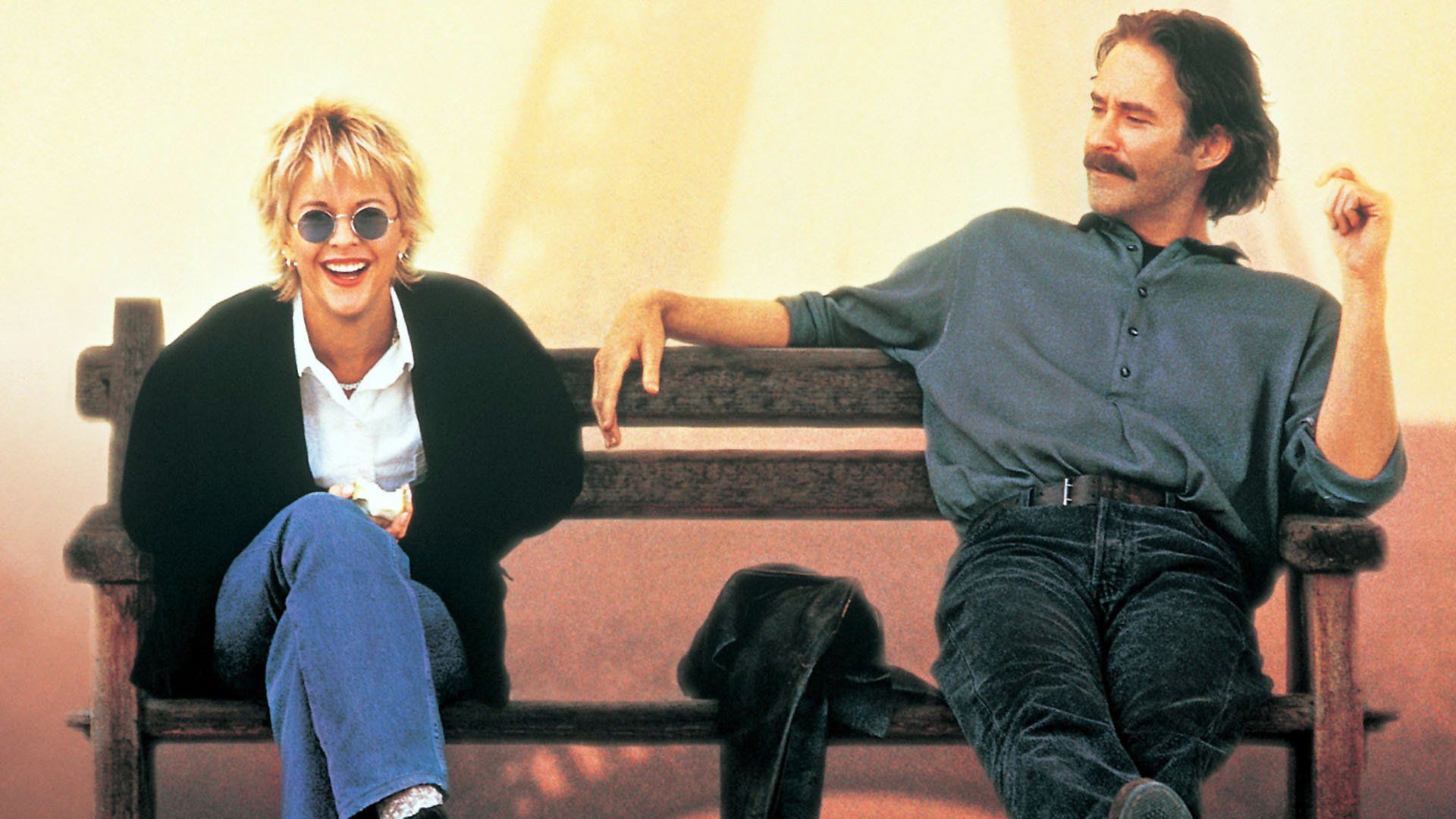 Meg Ryan și Kevin Kline stând pe o bancă, vorbind și râzând
