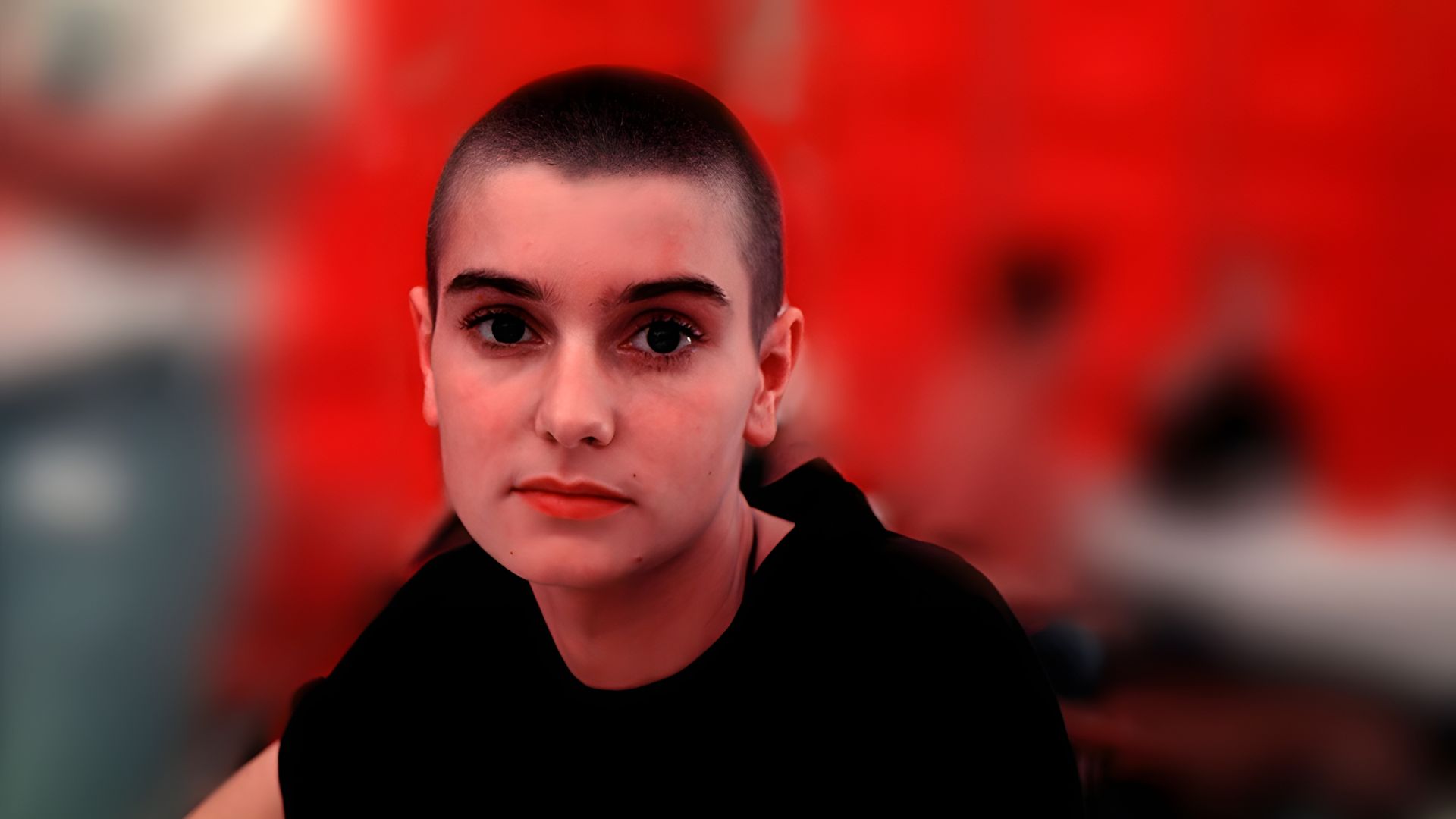 Tânăra Sinéad O'Connor fotografiată pe un fundal roșu