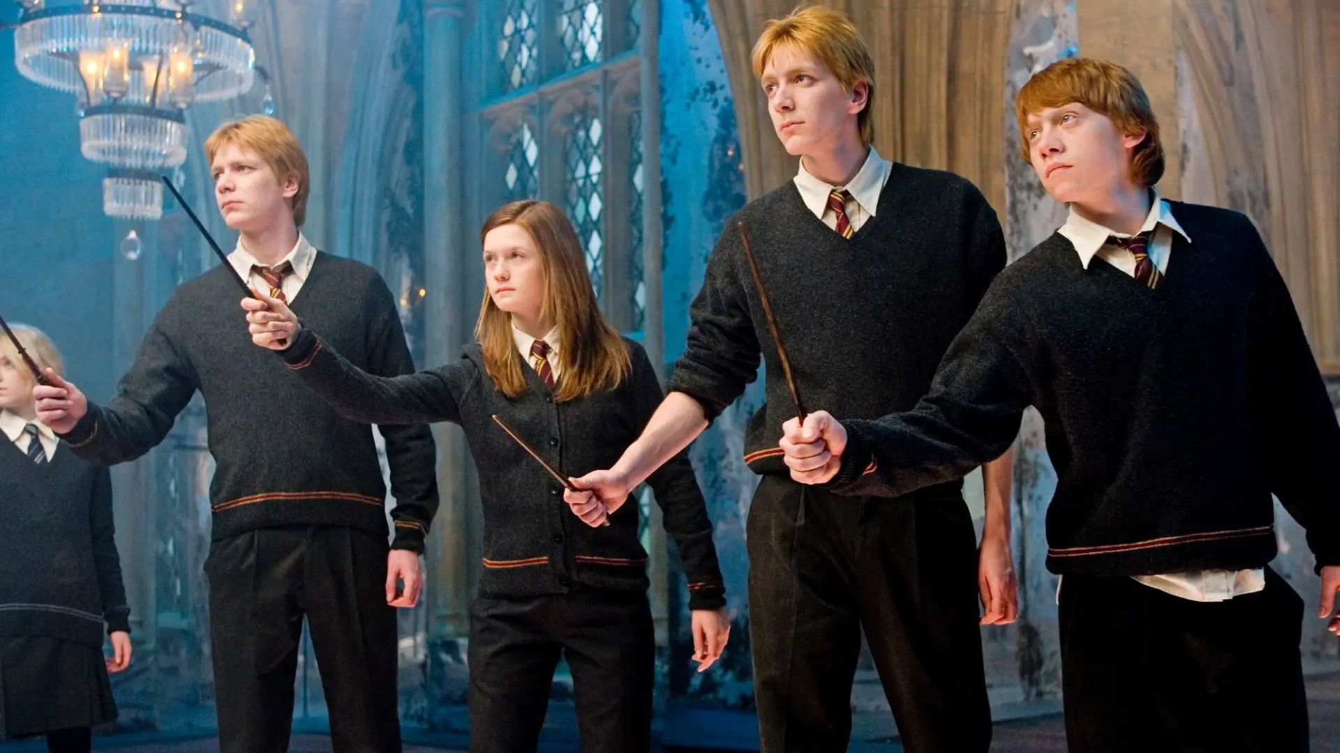 Gemenii Phelps, Bonnie Wright și Rupert Grint în uniforme școlare cu bețe magice