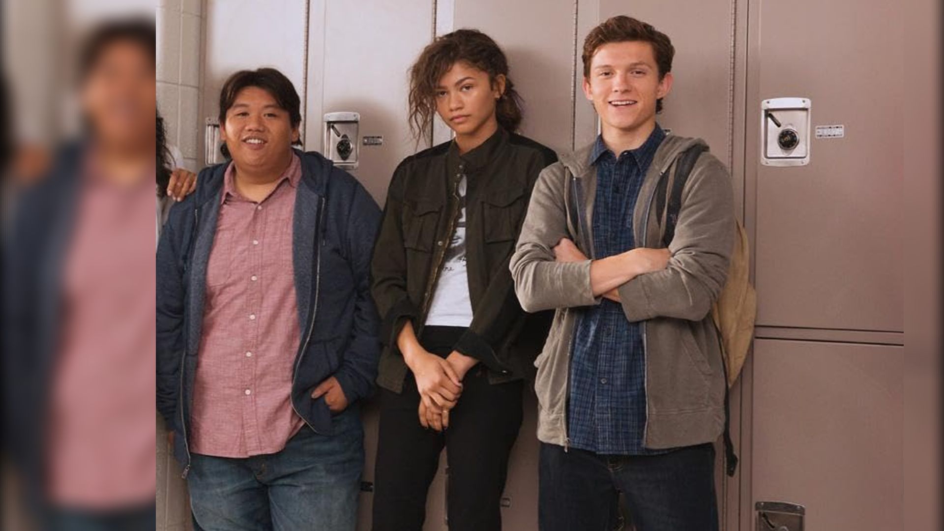 Actorii Jacob Batalon, Zendaya și Tom Holland în haine casual, stând lângă dulapurile din școală