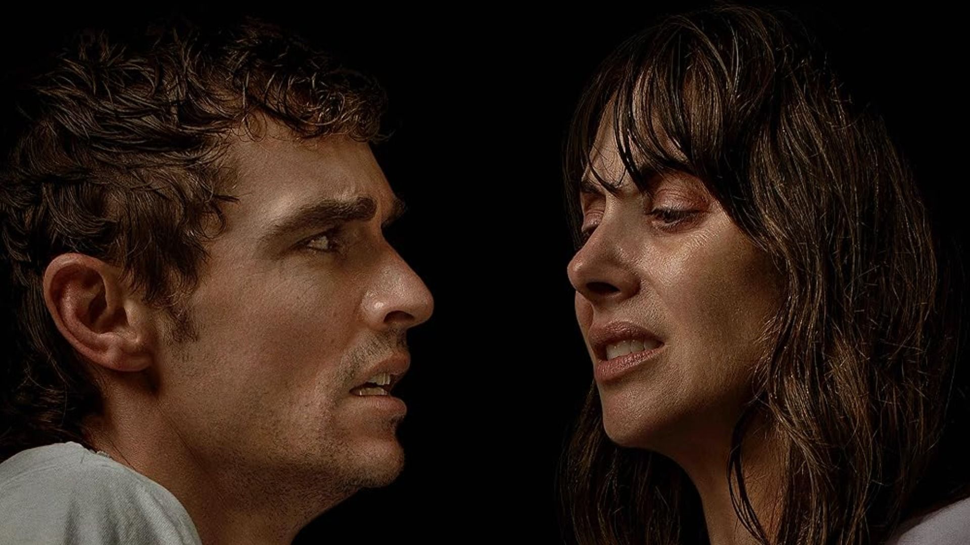 Actorii Dave Franco și Alison Brie se privesc cu expresii înfricoșate pe un fundal negru