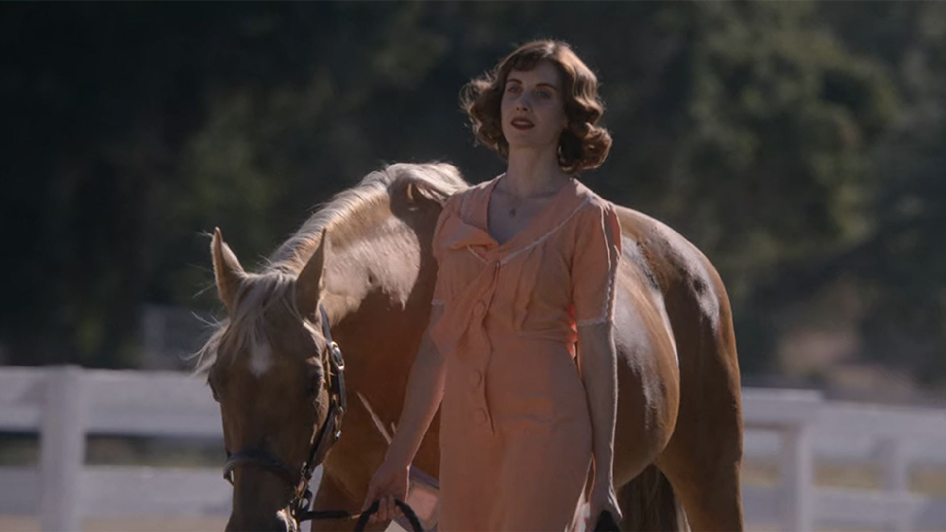 Alison Brie conducând un cal de hăți, cadru din filmul "Horse Girl"