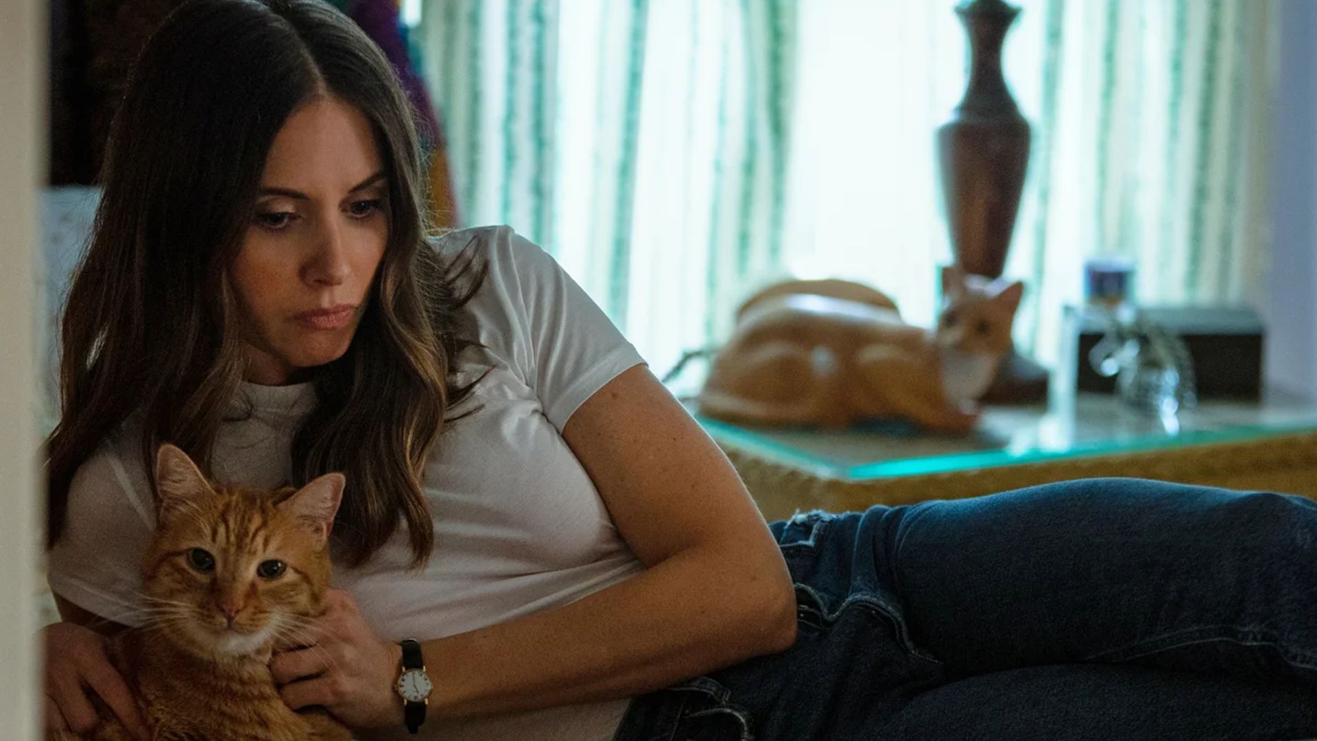 Alison Brie stă întinsă pe pat cu o pisică în brațe