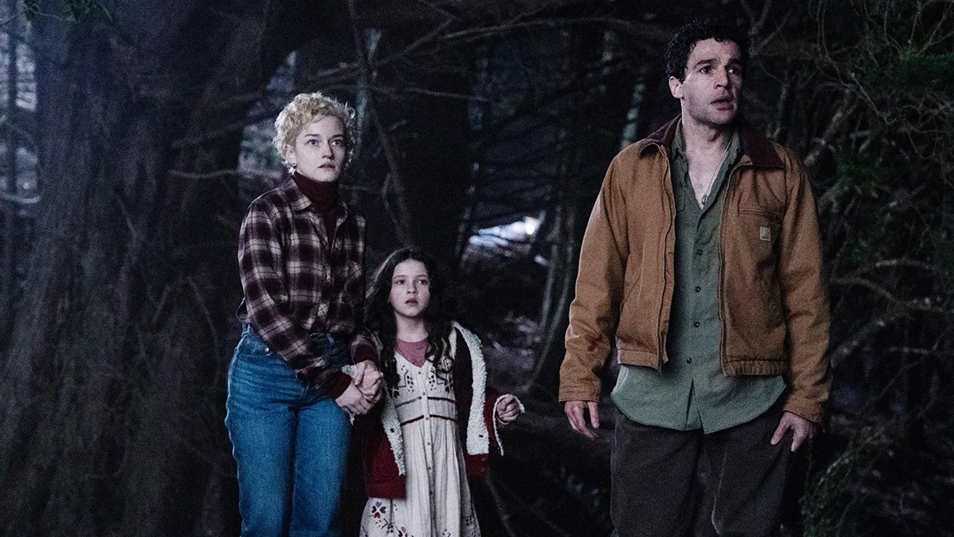 Julia Garner, Christopher Abbott și Matilda Firth într-o pădure nocturnă, cadru din filmul "Wolf Man"