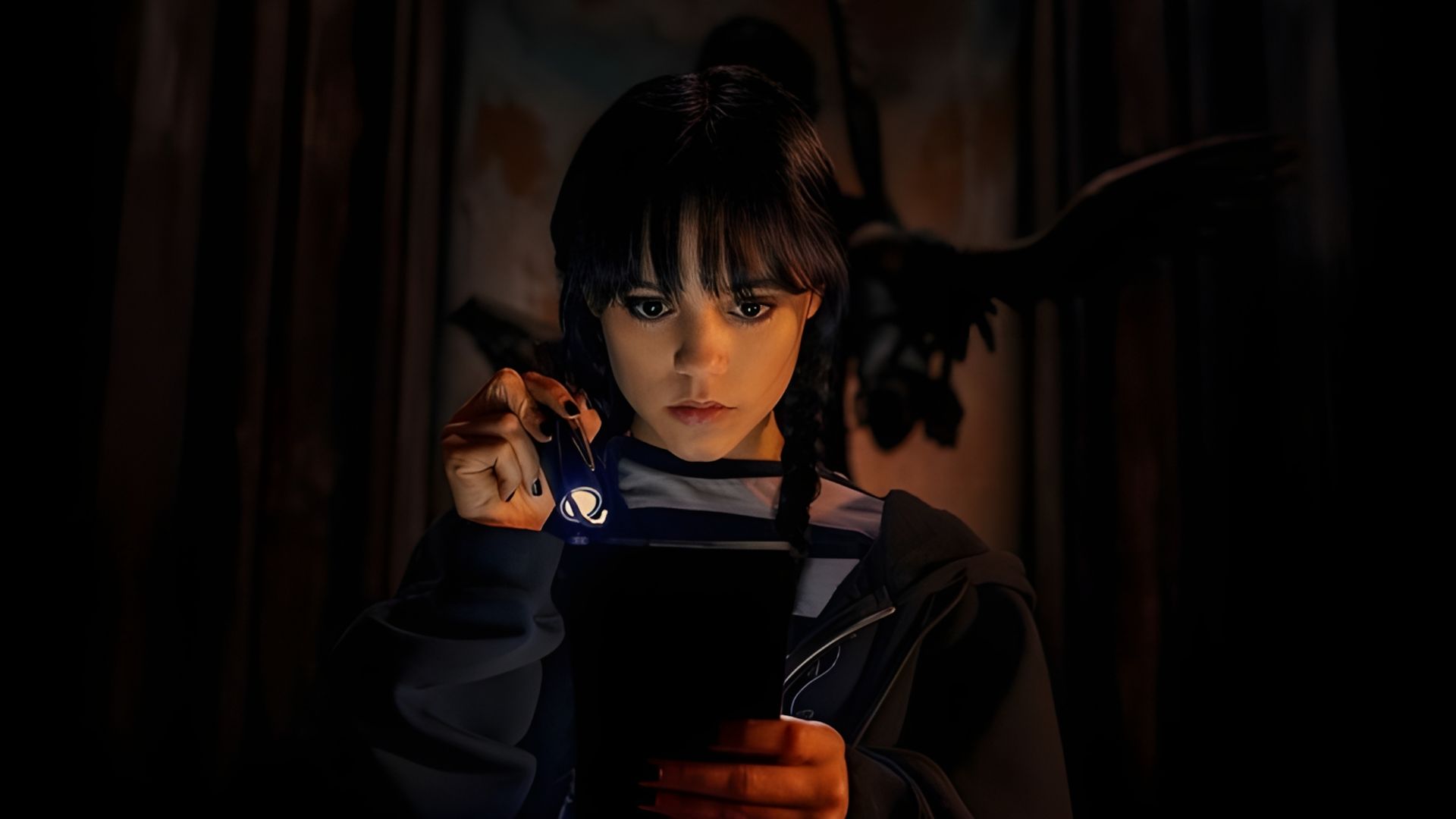 Jenna Ortega în rolul Wednesday Addams ținând o lanternă și uitându-se la o carte