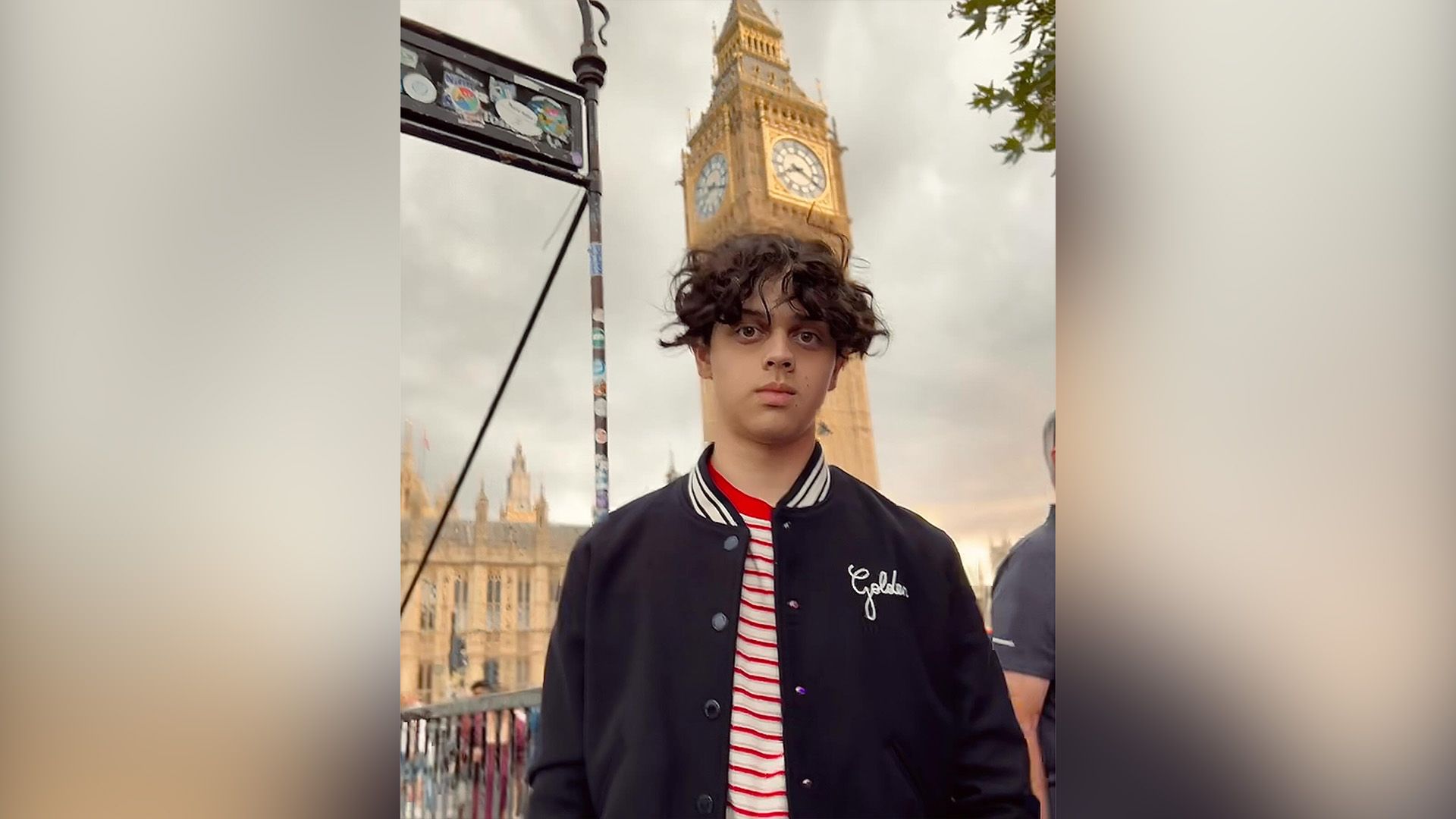 Isaac Ordonez într-o jachetă de baseball albastră pe fundalul turnului cu ceas Big Ben din Londra