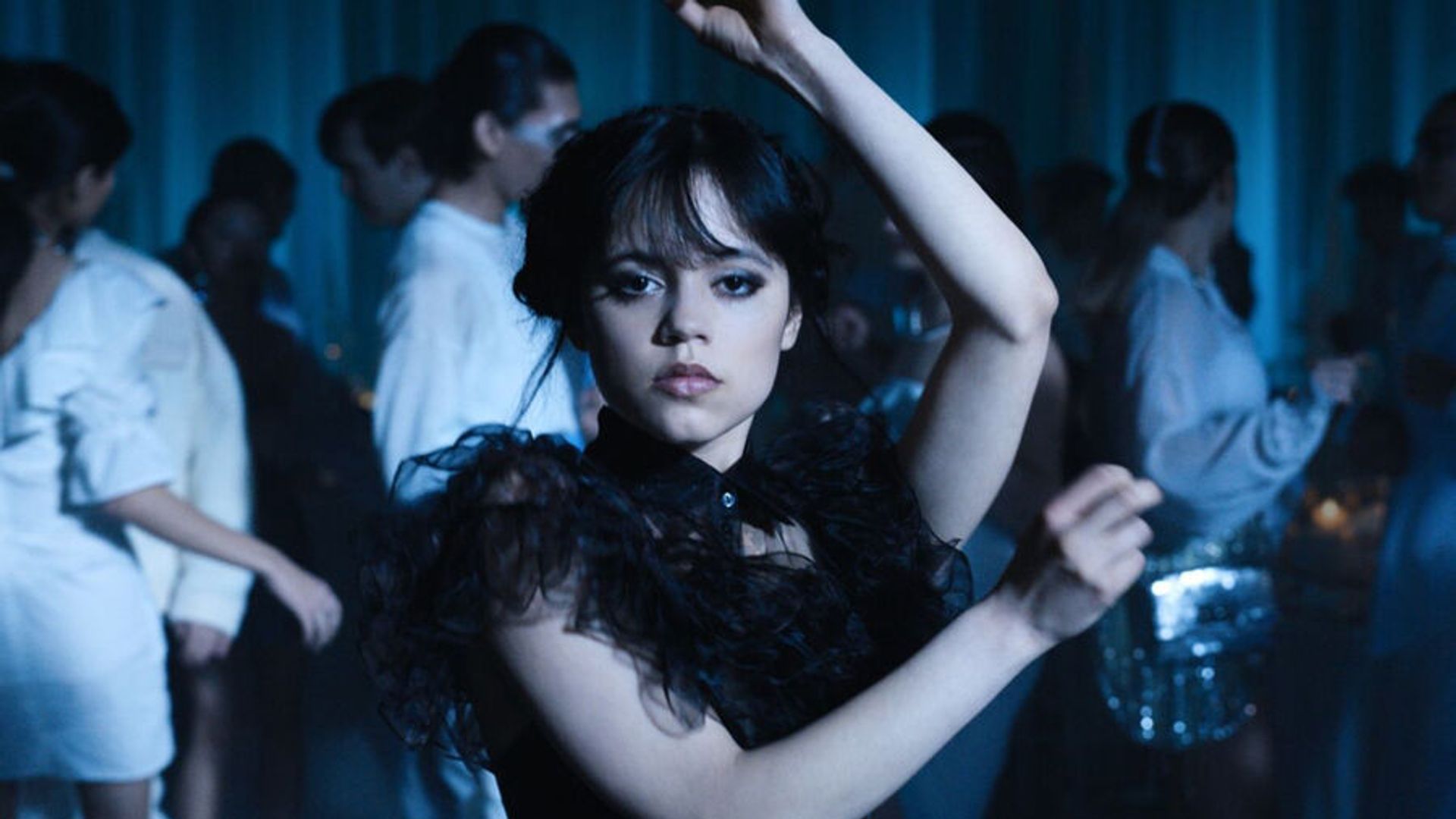 Jenna Ortega dansează într-o rochie neagră făcând mișcări angulare cu brațele