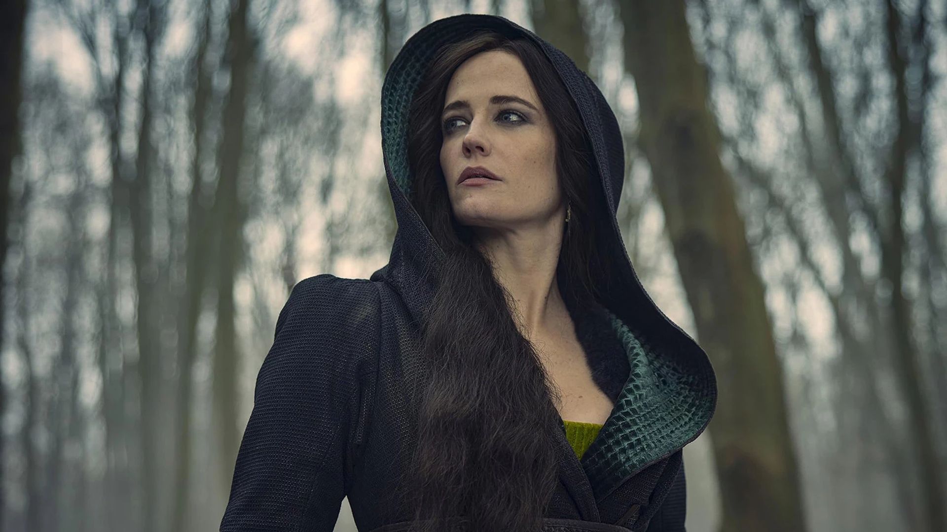 Eva Green într-o rochie neagră cu glugă pe fundalul unei păduri de iarnă