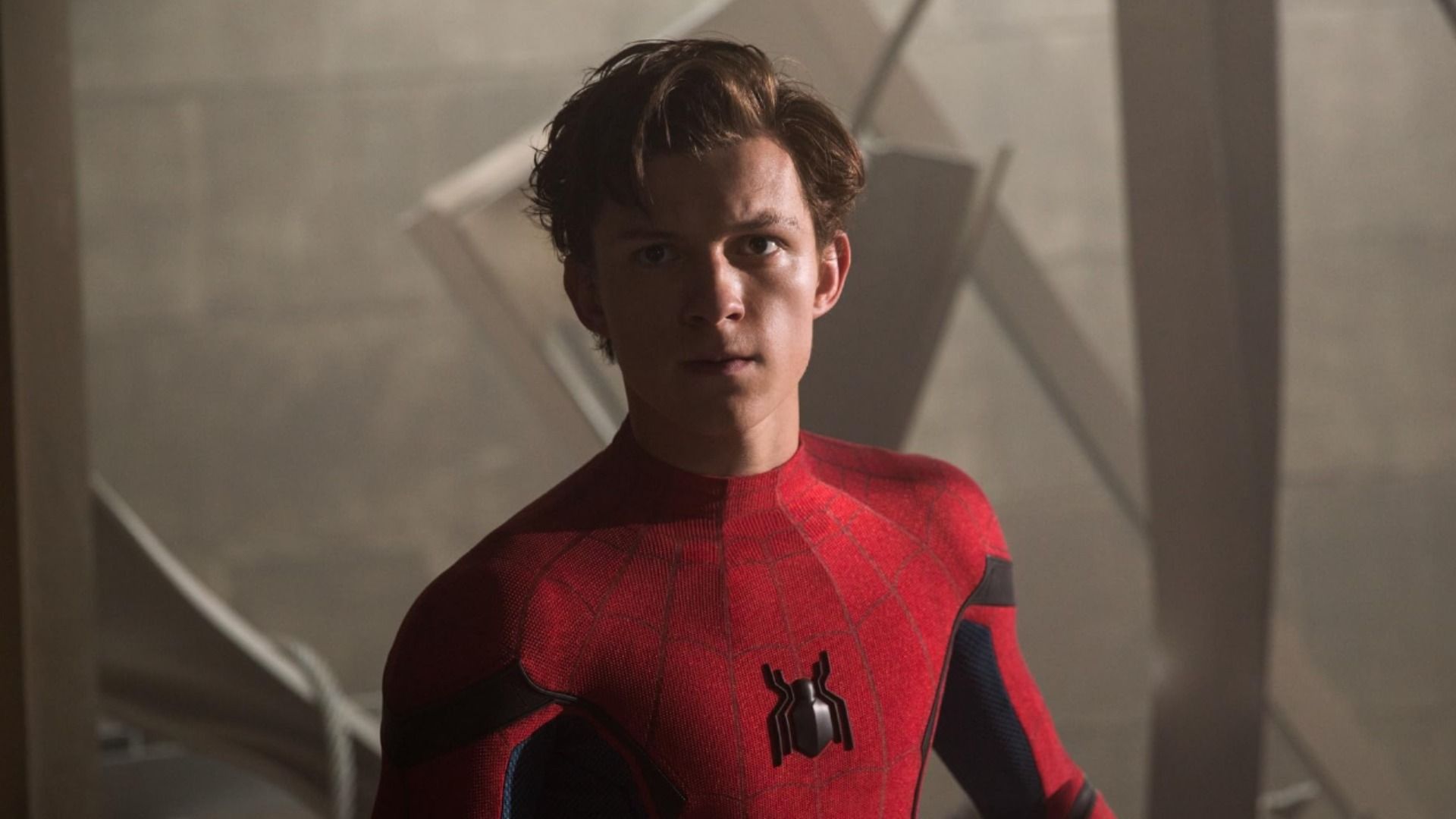 Actorul Tom Holland în costum de supererou roșu cu emblema păianjenului pe piept