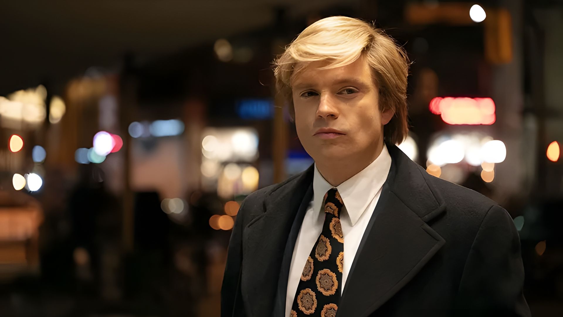 Sebastian Stan într-un costum și cu o perucă albă privind spre cameră