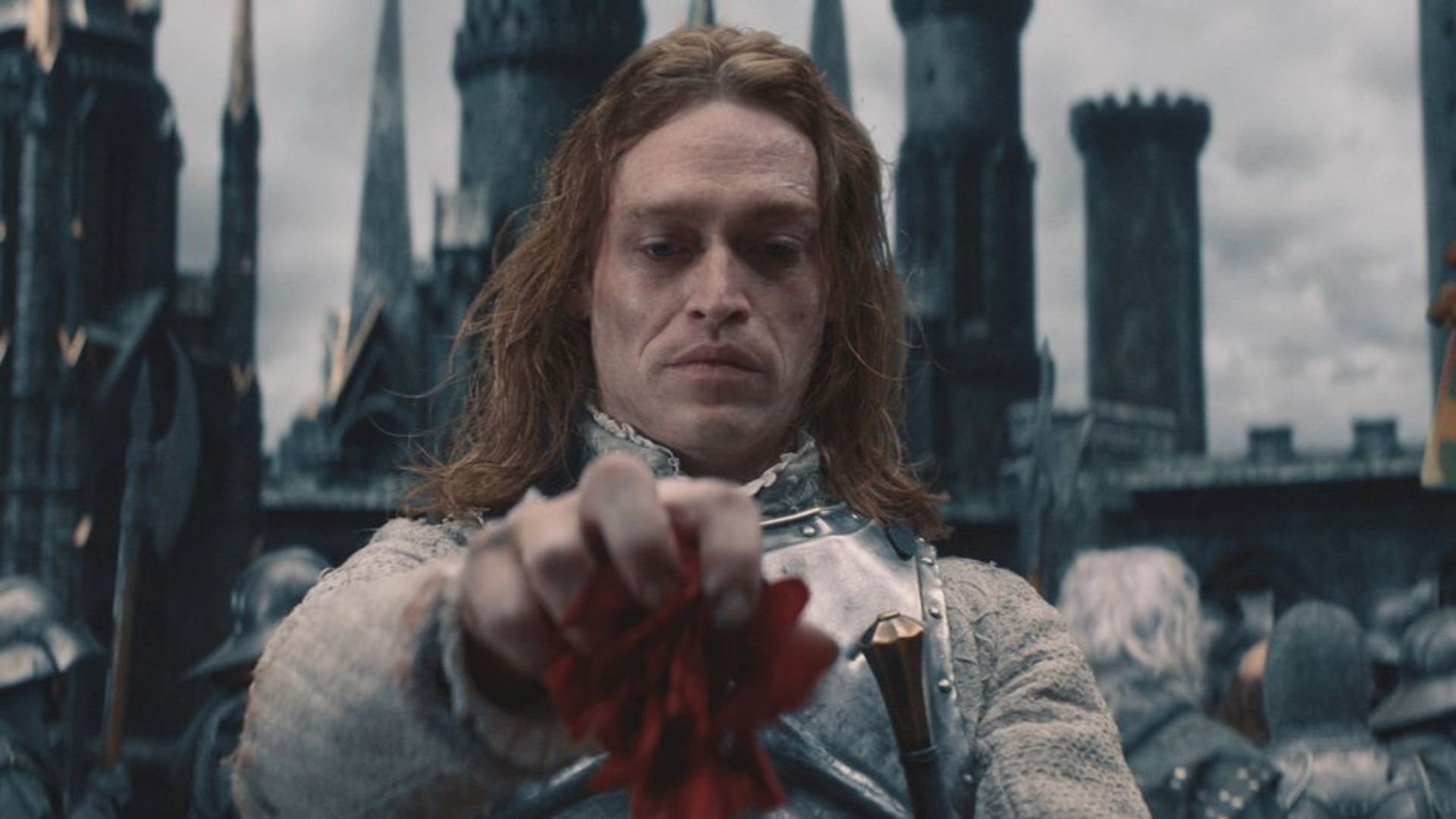 Caleb Landry Jones în machiaj de vampir privește în jos cu dispreț