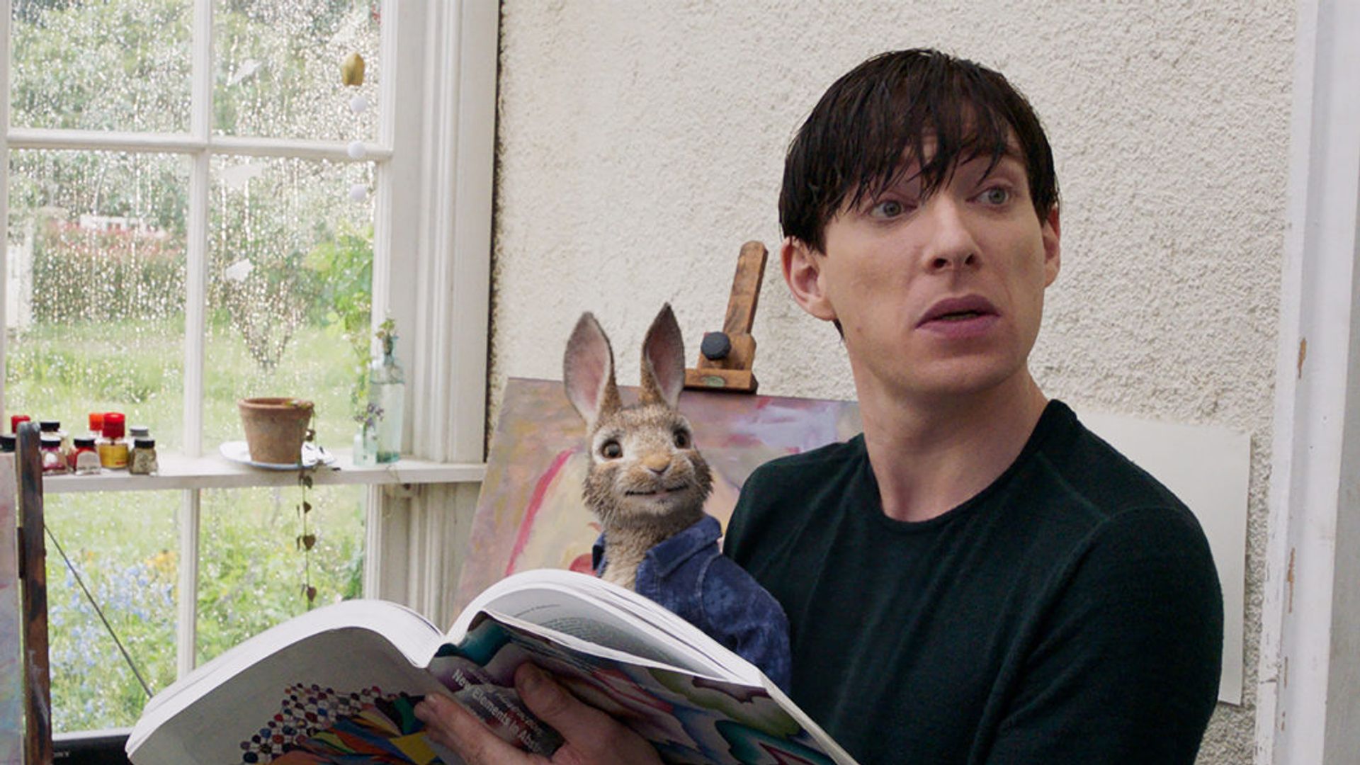 Domhnall Gleeson stă și citește un ziar cu un iepuraș de jucărie în poală