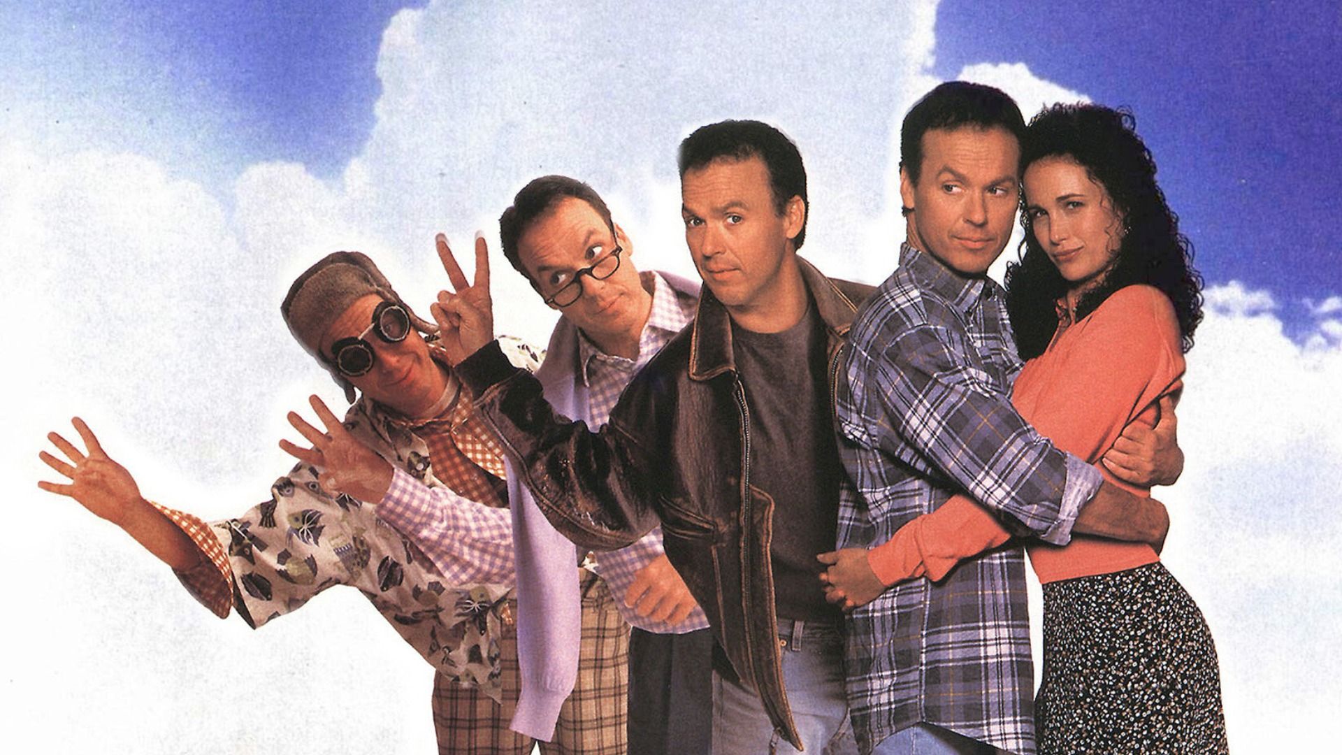 Patru versiuni ale actorului Michael Keaton stând în îmbrăcăminte diferită, una dintre ele îmbrățișând-o pe actrița Andie MacDowell